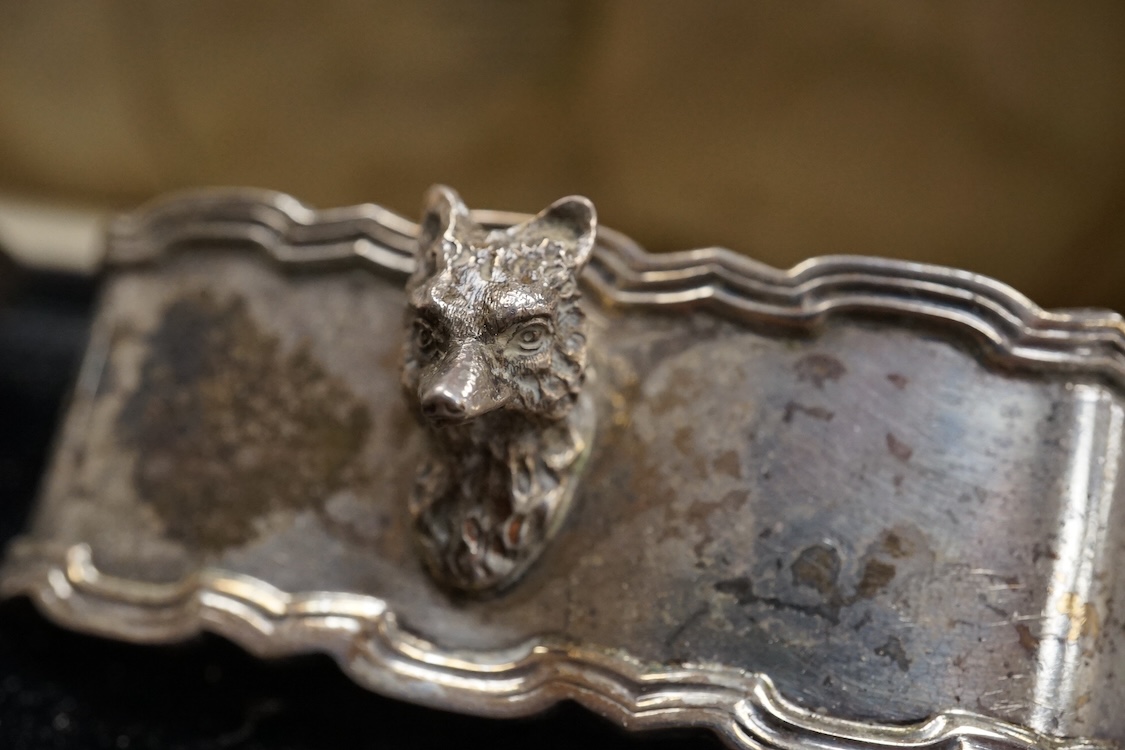 A cased pair of George V silver oval napkin rings, each with a fox head surmount, Adie Brothers, Birmingham, 1928, 72mm.